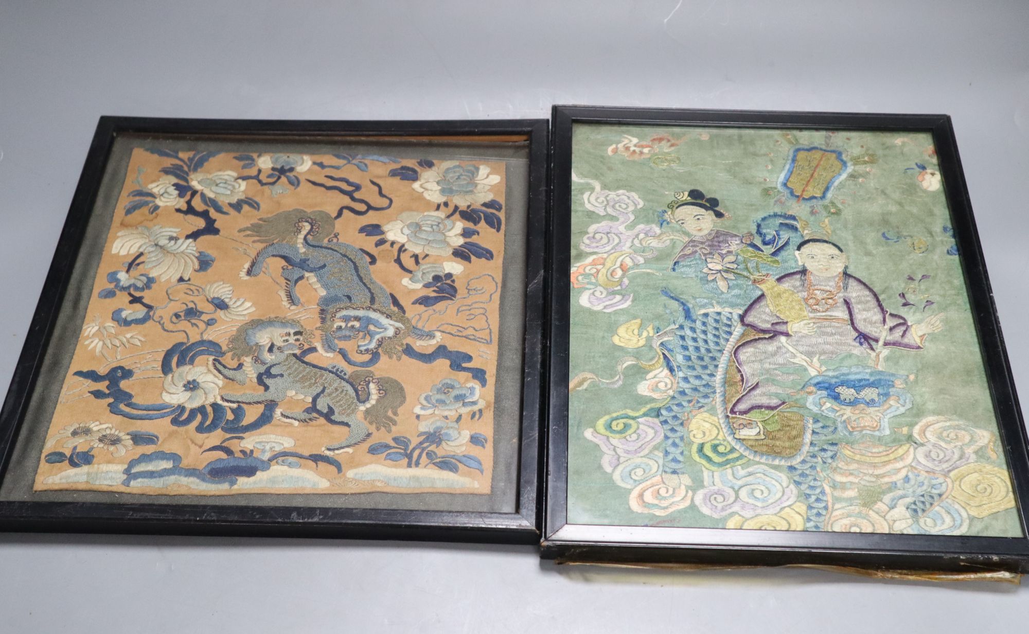 Two Chinese embroidered silk panels of He Xiangu riding a dragon and two Buddhist lions amid peonies, 19th century